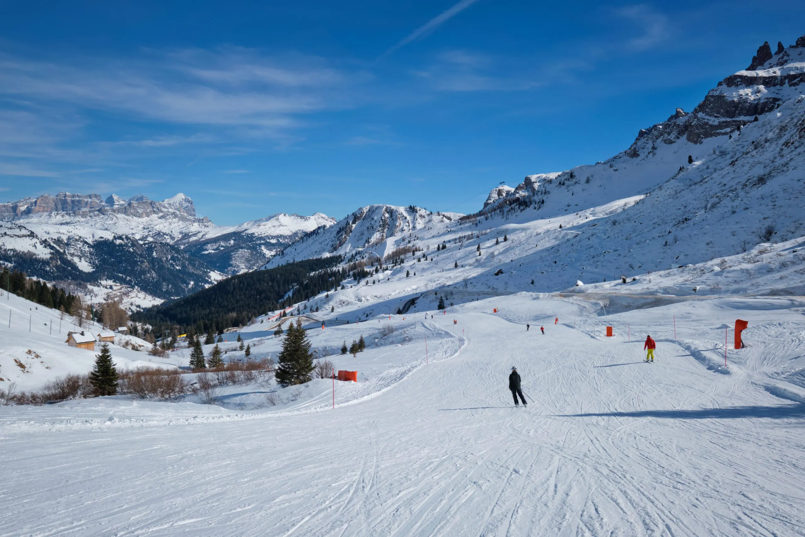 Canazei, Italy - February 16, 2019: View of a ski resort piste with people skiing in Dolomites in Italy. Canazei, Italy