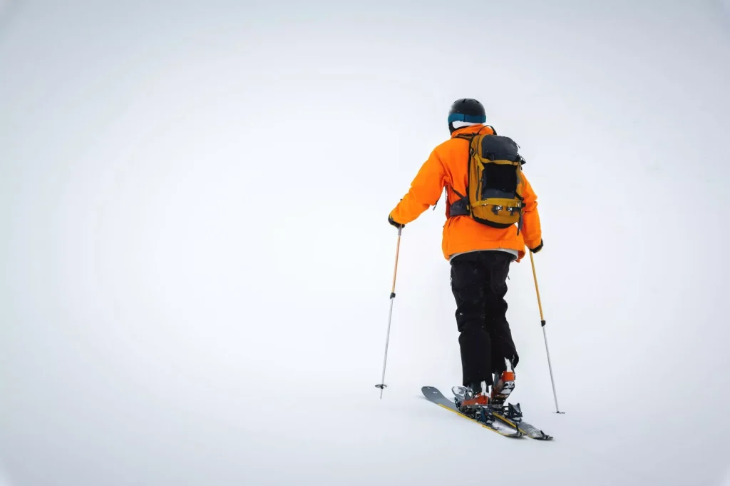 Ski tourist goes uphill. Snow and winter sports, ski touring in the mountains, entertainment.